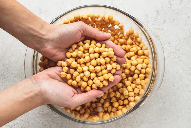 Dry chickpeas are soaked overnight in water and baking soda to ready them for falafel making