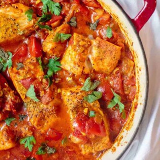 Fish fillet cooked with tomato sauce and served shakshuka style in a braiser