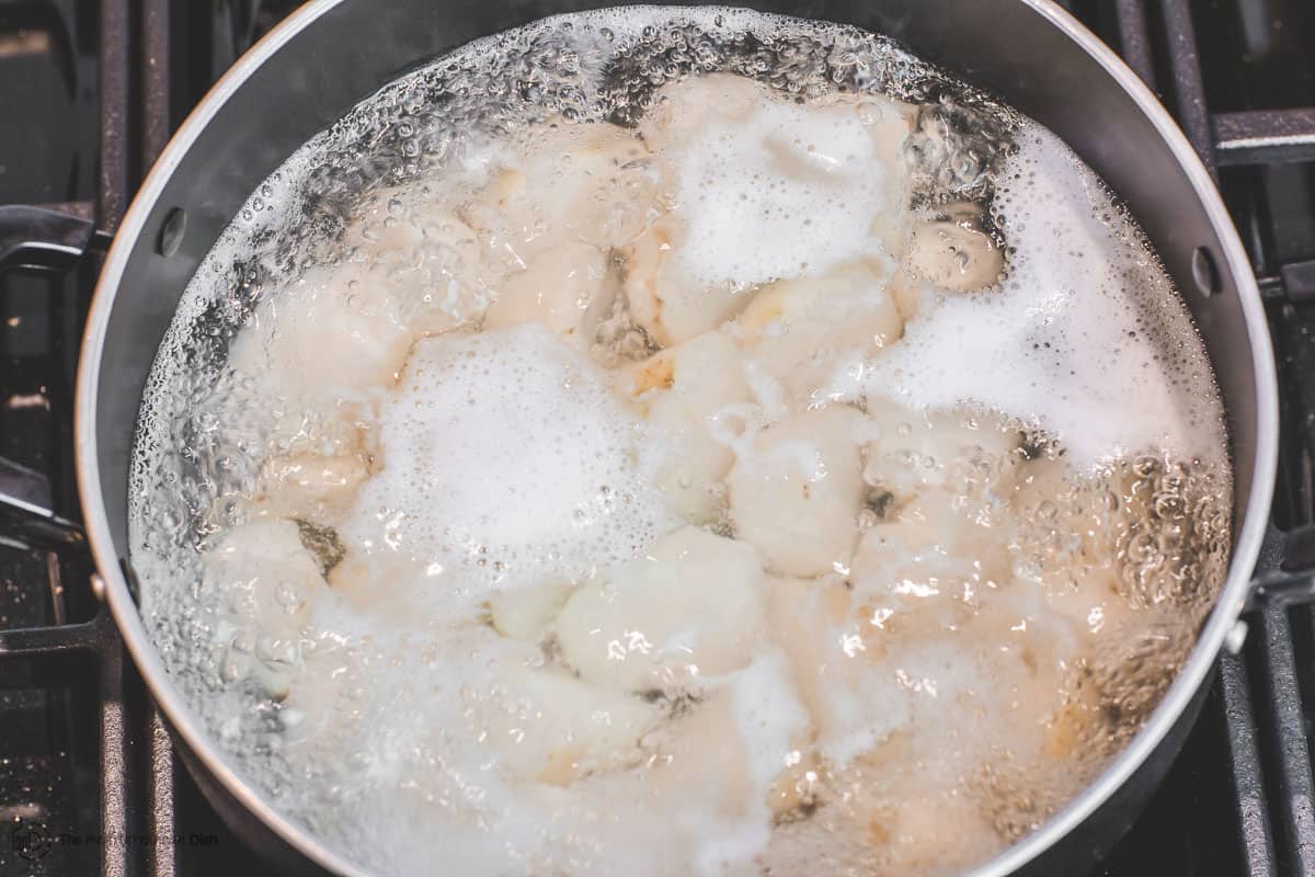 Potatoes are boiling in a pot of water