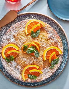 orange cardamom olive oil cake topped with orange slices.