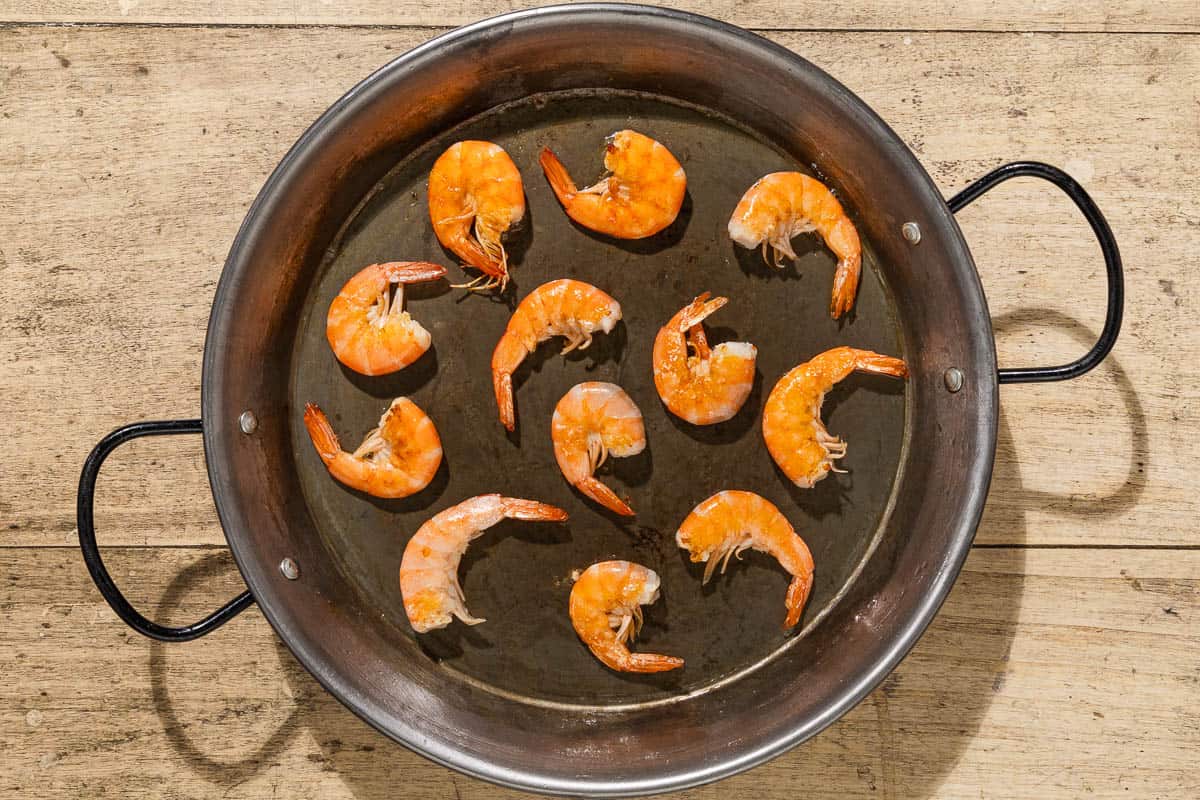 An overhead photo of shrimp cooking in a skillet.