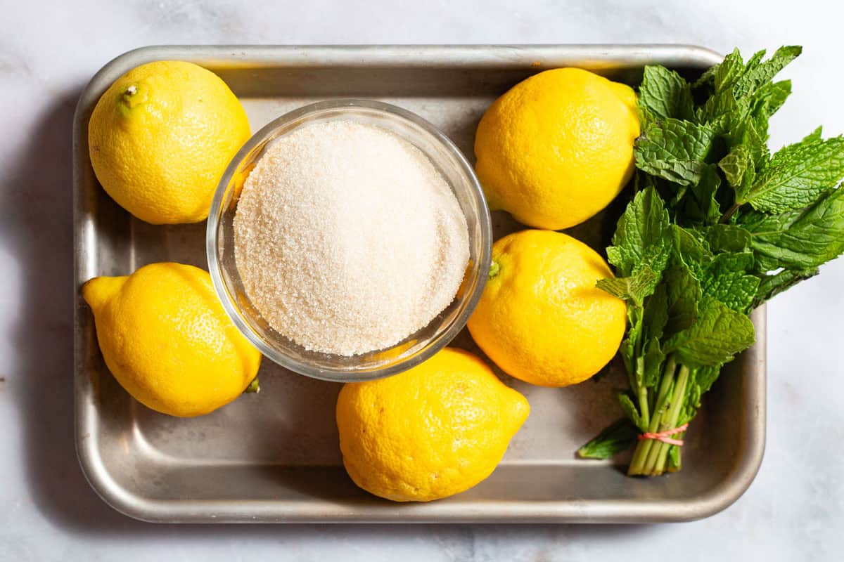 Ingredients for lemon sorbet including lemons, mint and sugar.