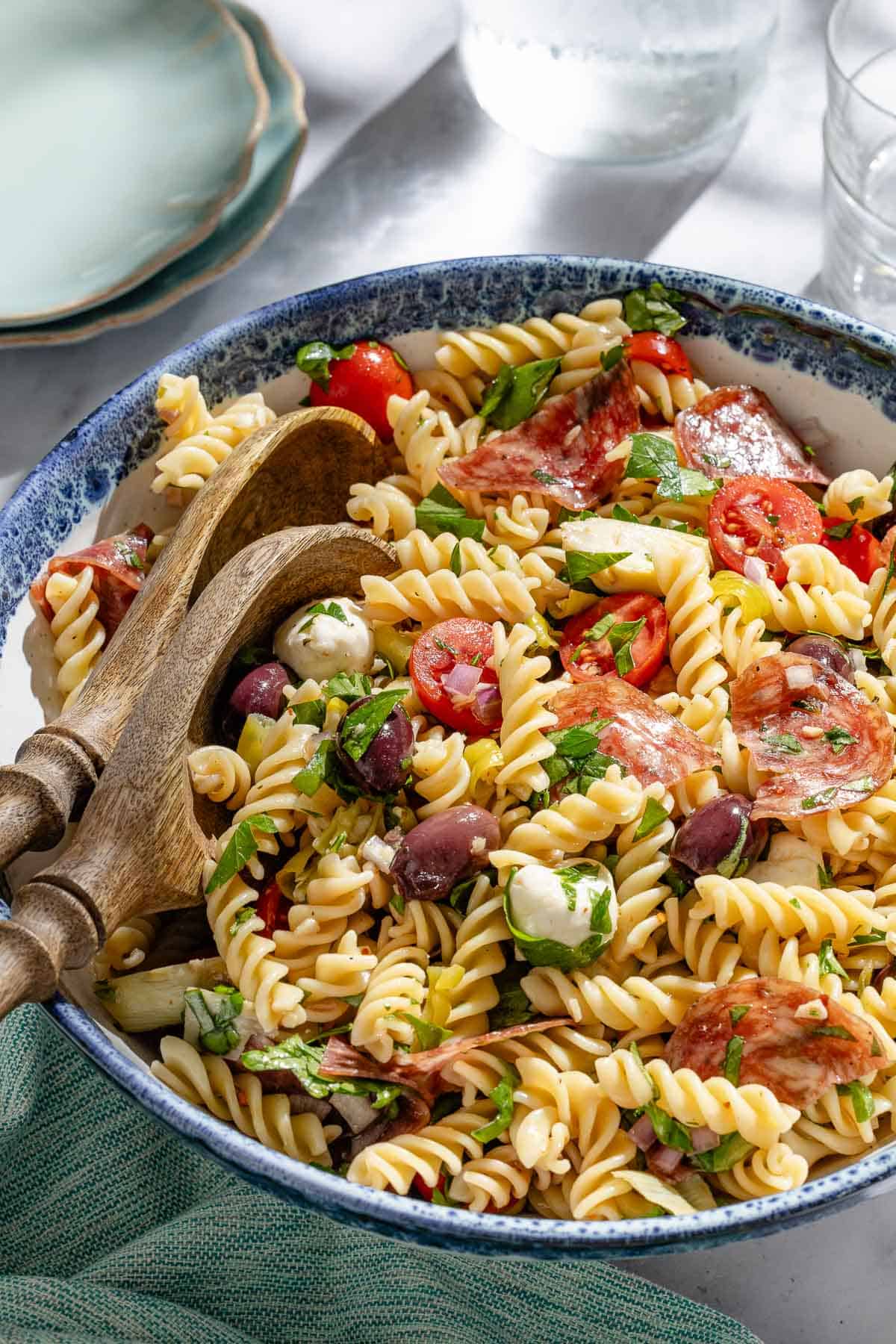 Side shot of Italian pasta salad in a serving bowl on a sunny day.
