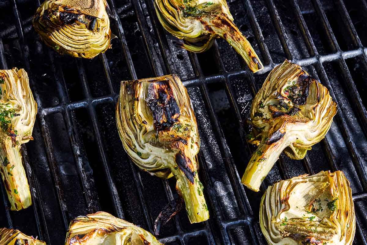 Artichoke quarters being grilled on a grill.