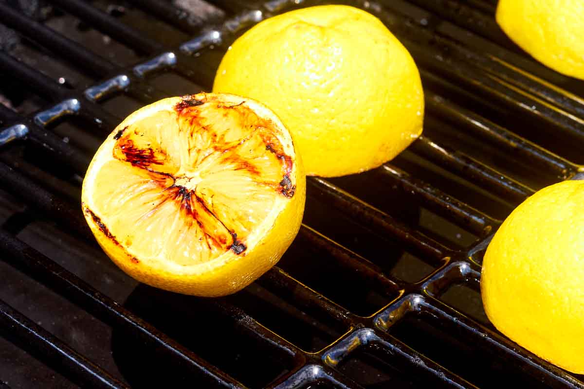 Lemon halves being grilled on an outdoor grill.