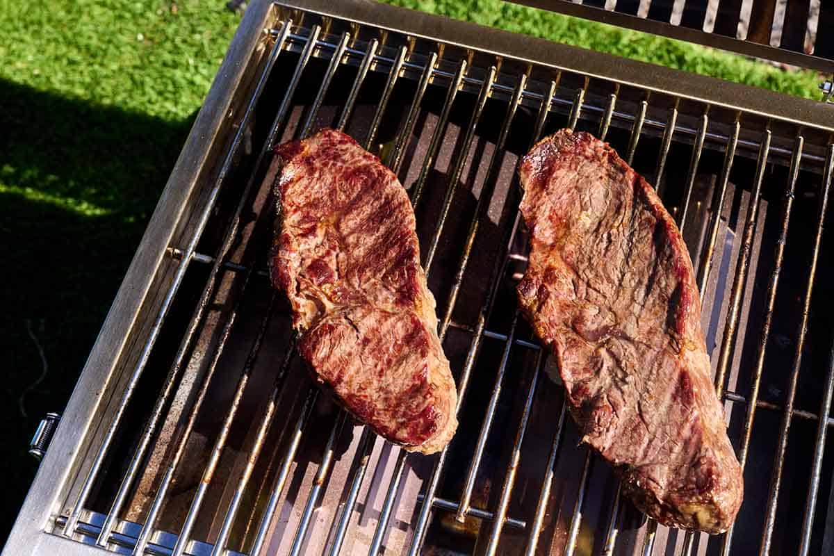 2 sirloin steaks being grilled.
