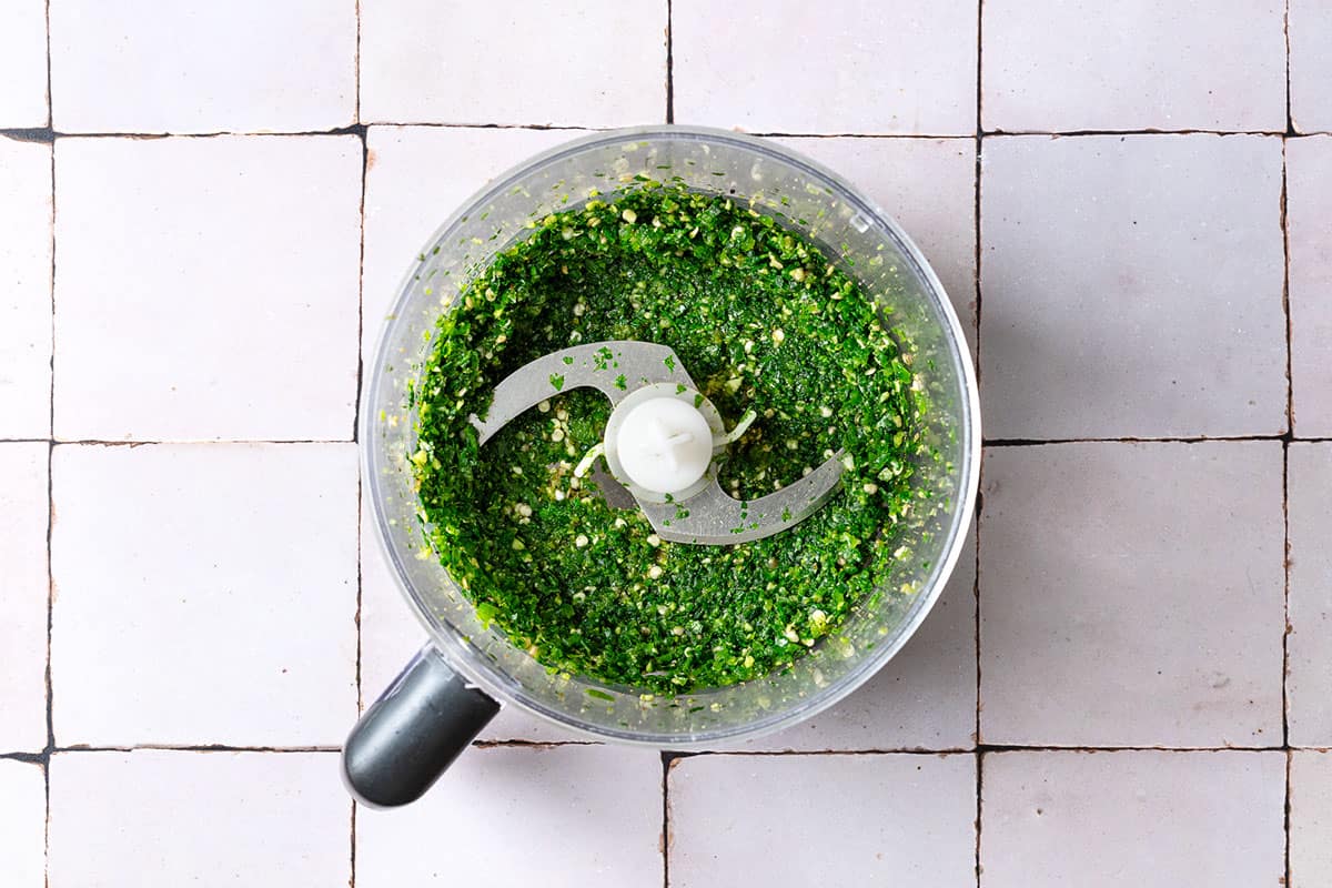 The jalapeno, garlic, cilantro, parsley, cumin, coriander and cardamom formed into a paste in the bowl of a food processor fitted with a blade.