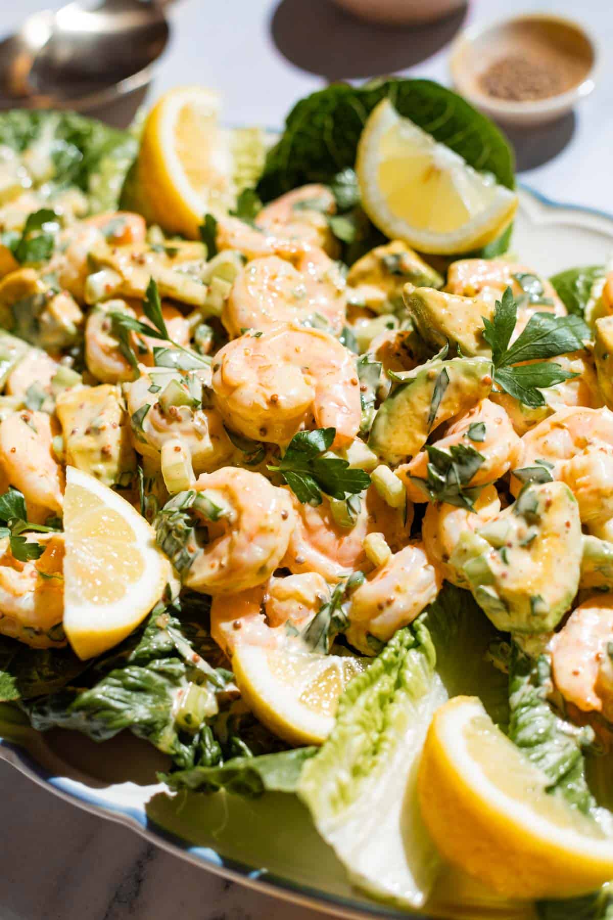 Close up shot of shrimp salad, showing the creamy dressing and parsley garnish.