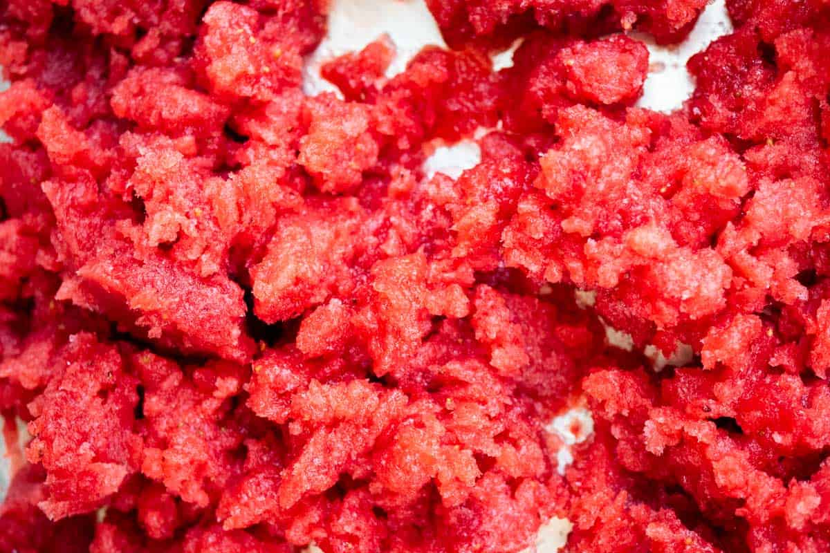 A close up of strawberry granita just after it's been broken up.