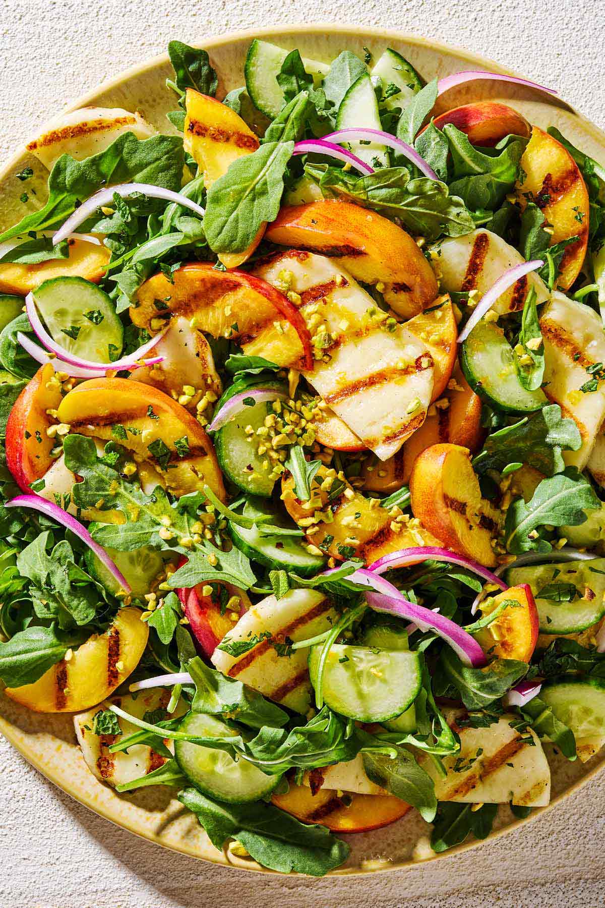 A close up of halloumi and peach salad on a platter.