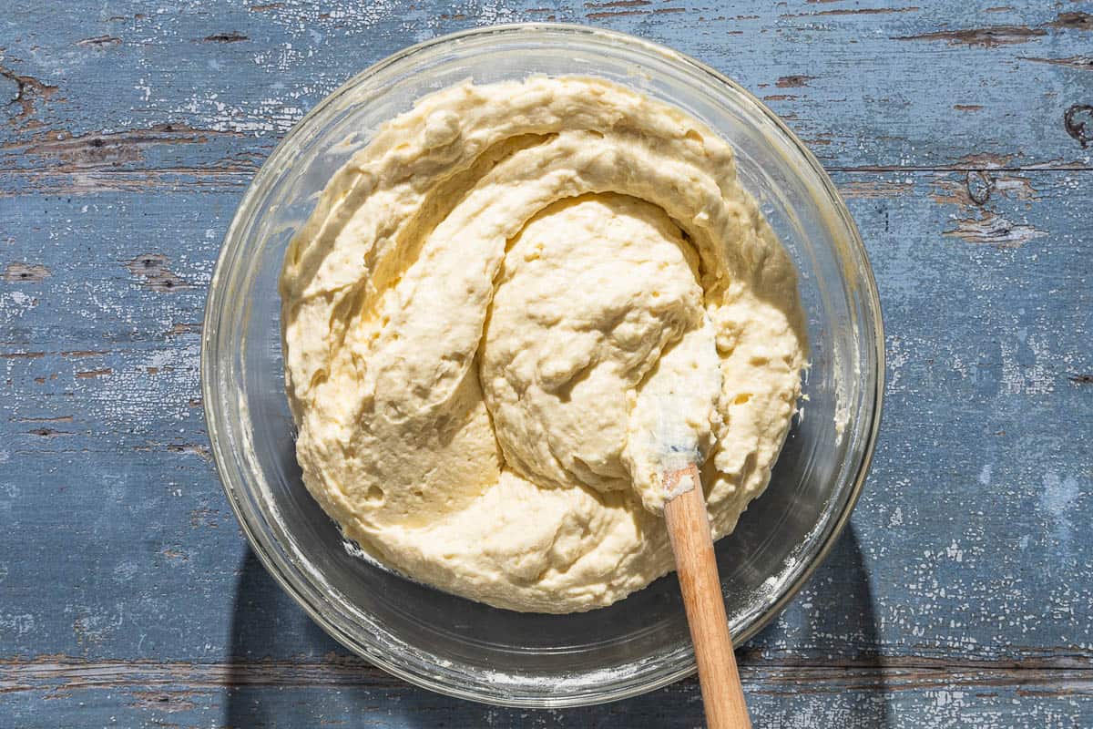 The batter for the lemon ricotta cake in a mixing bowl with a wooden spoon.