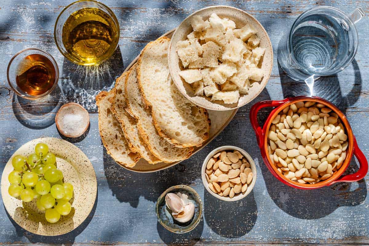 Ingredients for ajo blanco white gazpacho including blanched almonds, bread, garlic, water, sherry vinegar, sea salt, olive oil and green grapes.