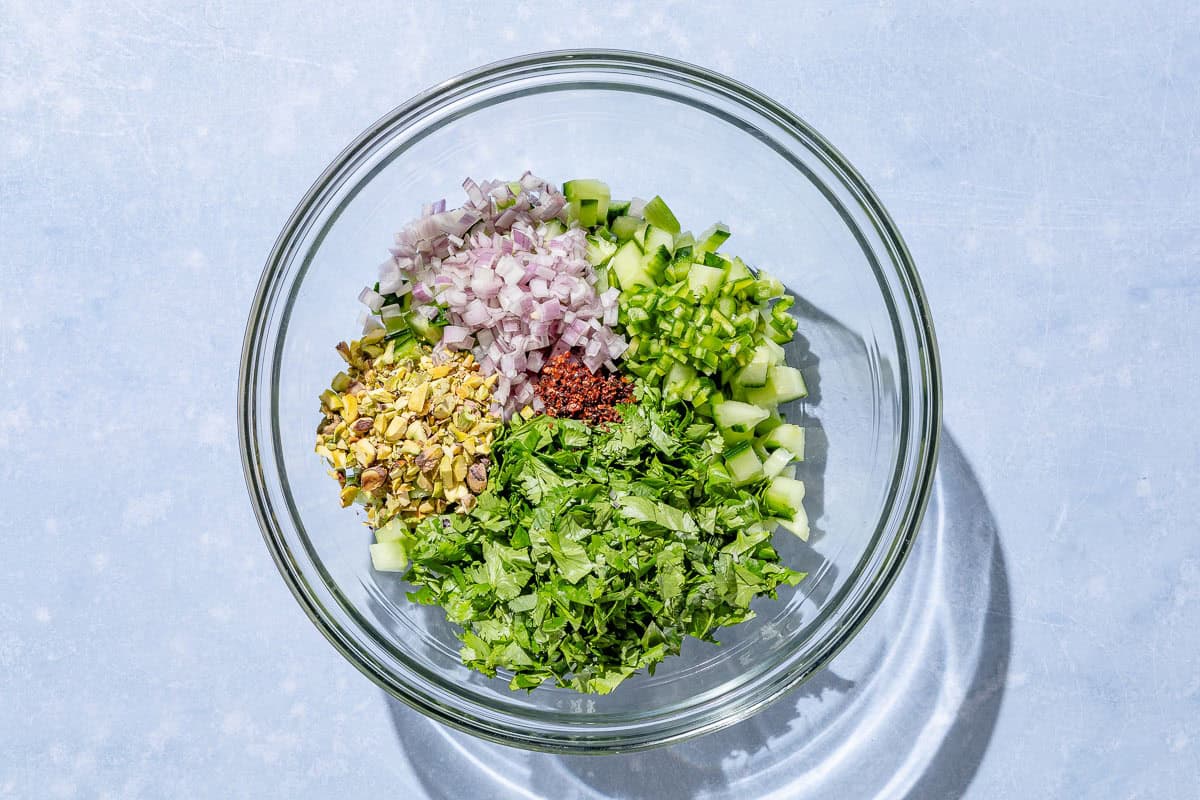 The ingredients for the cucumber salsa in a bowl just before being mixed together.