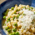 A close up of pasta with peas in a bowl.