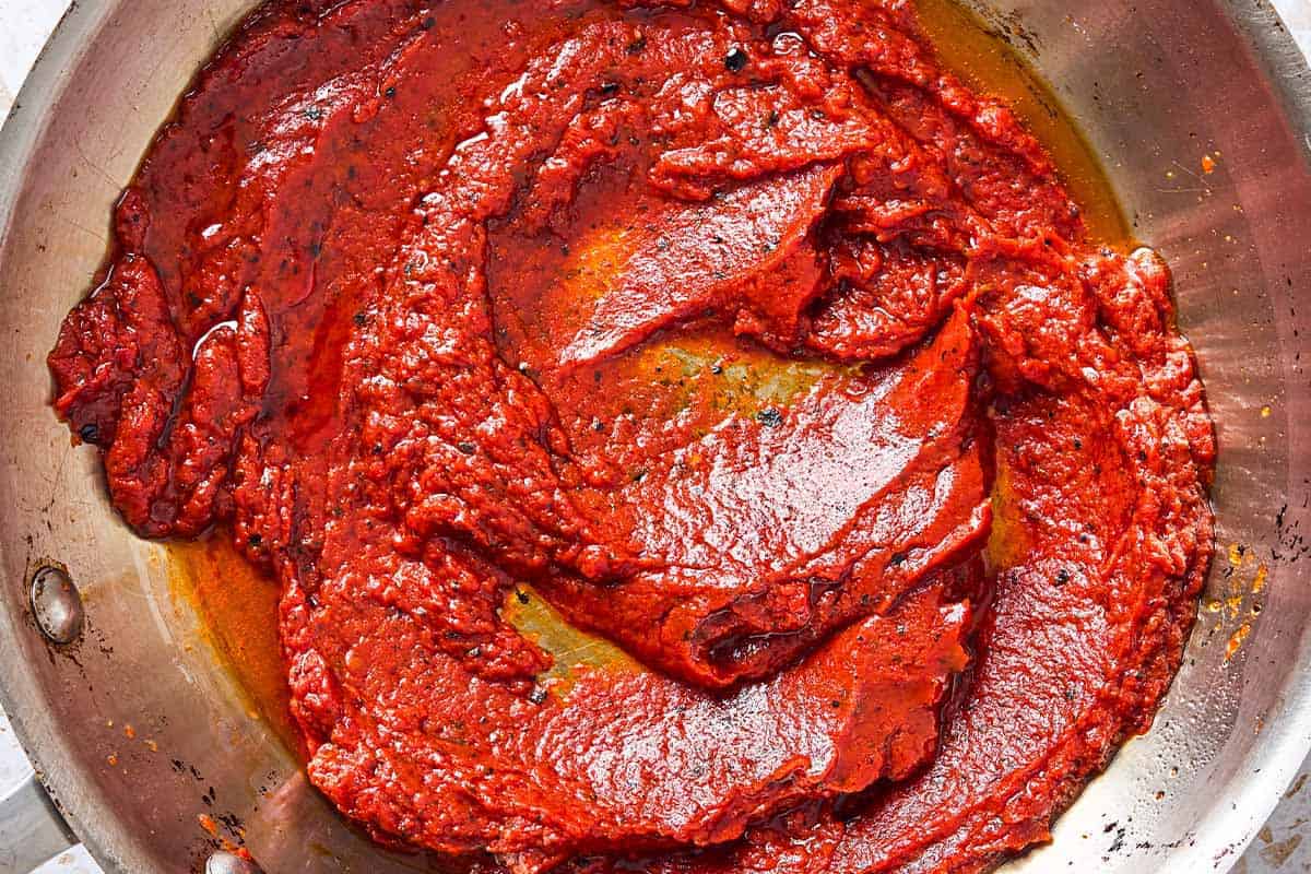 The ingredients for the paste for the kisir turkish bulgur salad being combined and heated in a skillet.