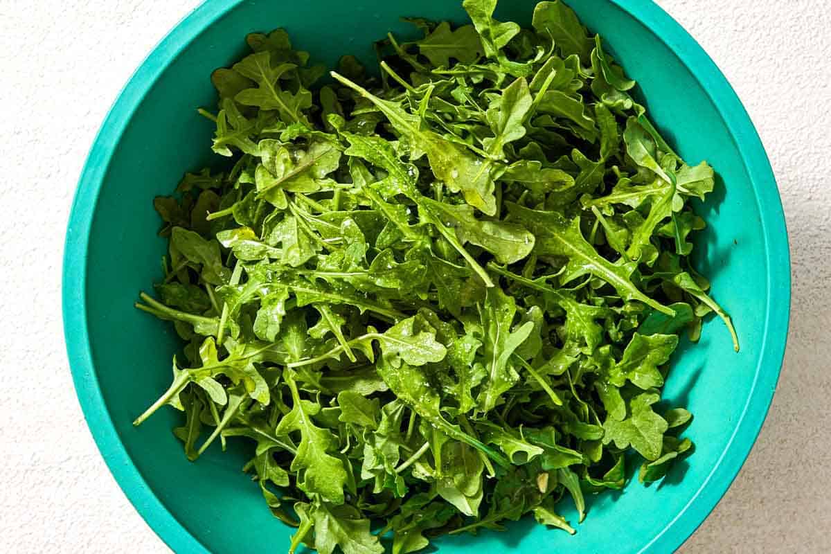 An overhead photo of arugula in a bowl.