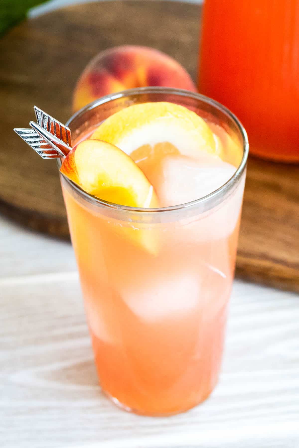 A close up photo of a glass of peach lemonade.