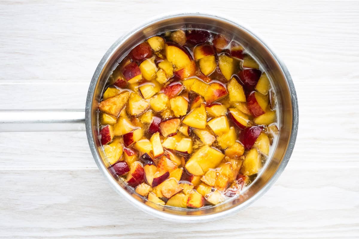 Chopped peaches simmering in a pot.