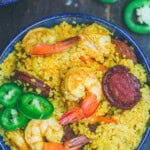 An overhead photo of shrimp couscous in a bowl. Next to the bowl is 3 jalapeno slices.