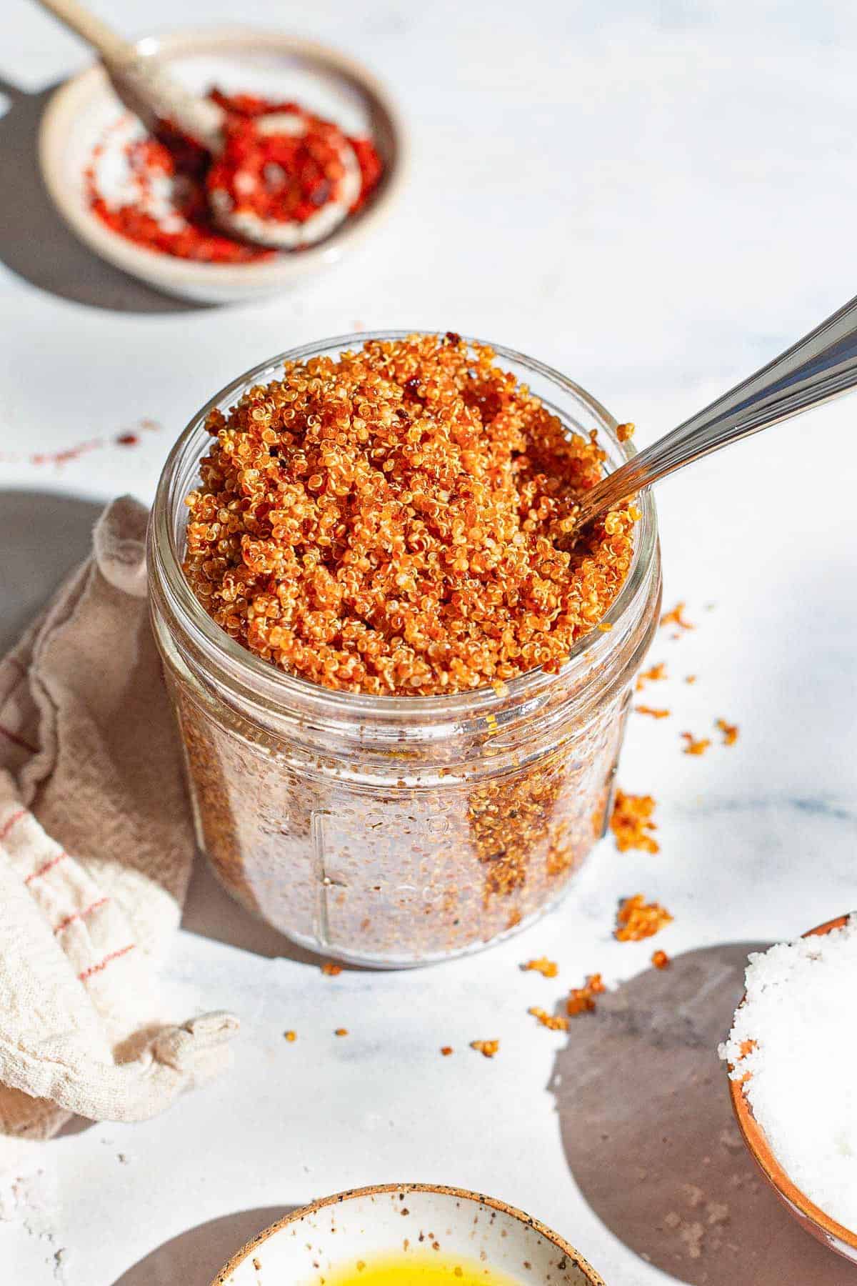 crispy quinoa in a jar with a spoon.