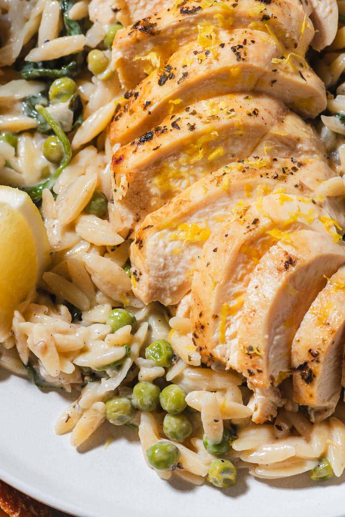 A close up of a serving of lemon chicken orzo on a plate.