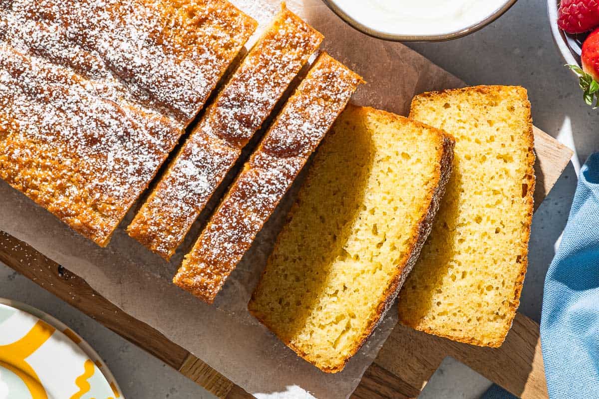 An overhead photo of yogurt cake cut into slices on a parchment lined cutting board.