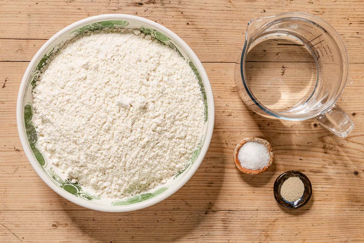 Ingredients for neapolitan pizza dough including flour, instant yeast, salt, and water.