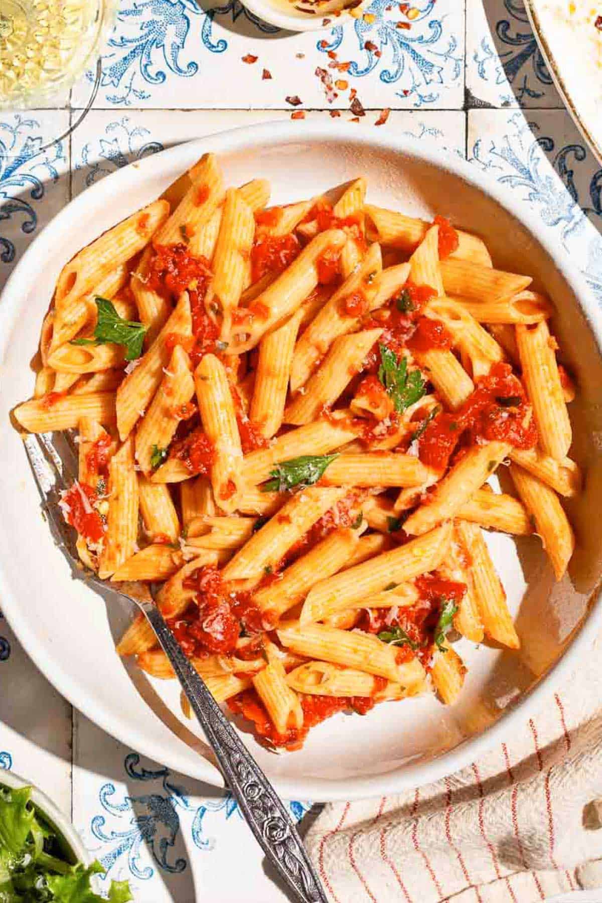 An overhead photo of arrabbiata sauce pasta in a bowl with a fork.