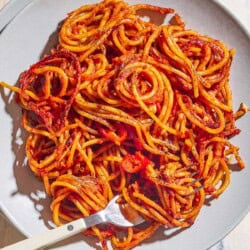 An overhead photo of a serving spaghetti all'assassina on a plate with a fork.