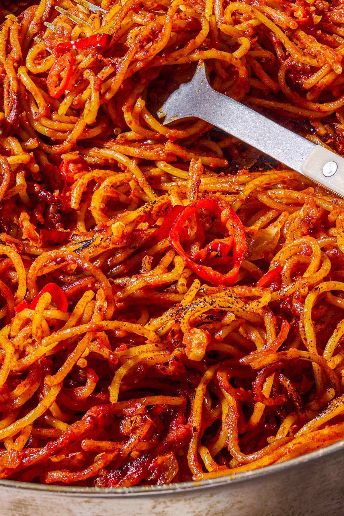 A close up of spaghetti all'assassina with a fork.