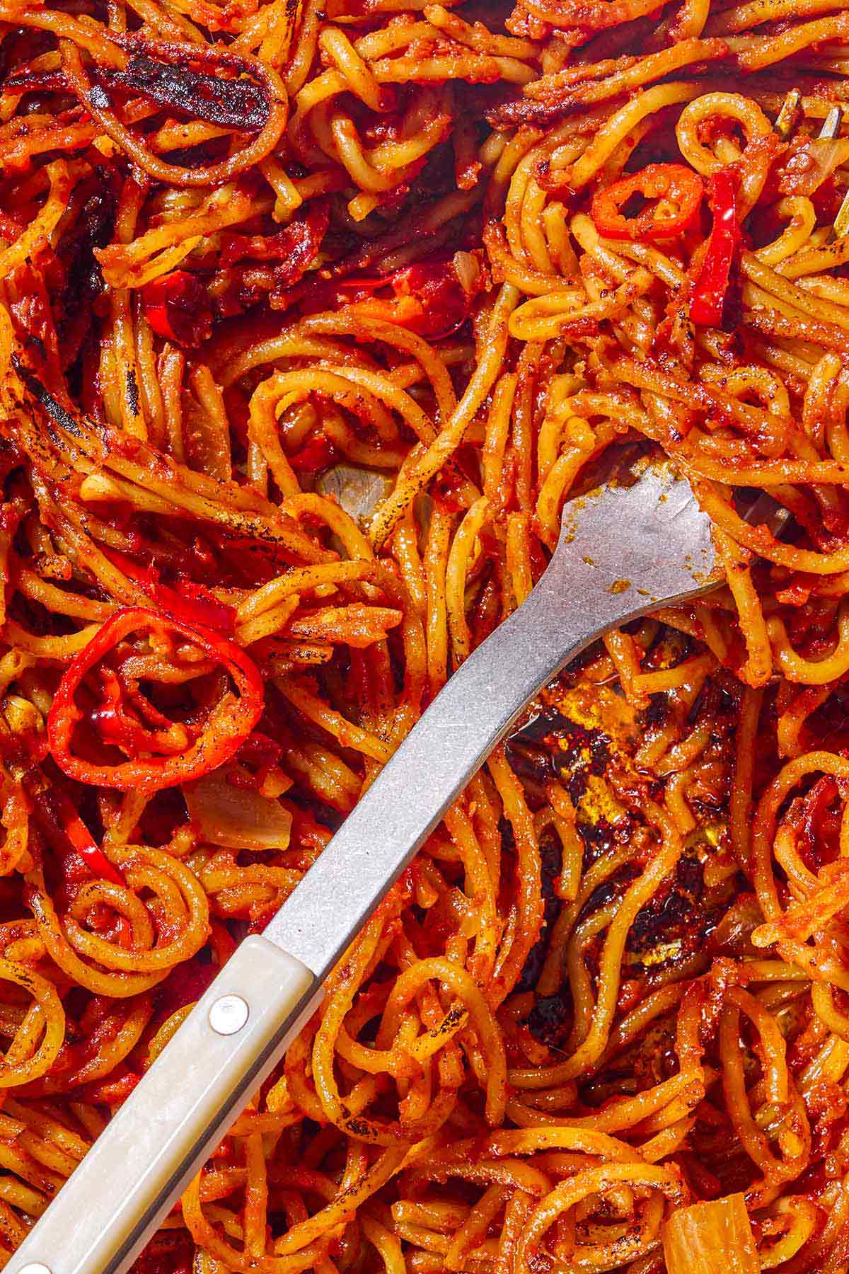 A close up of spaghetti all'assassina with a fork.