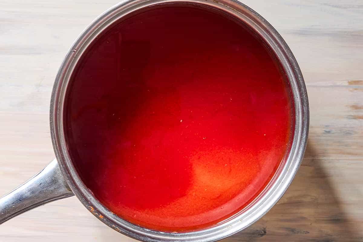 Tomato sauce simmering in a wide, deep skillet.