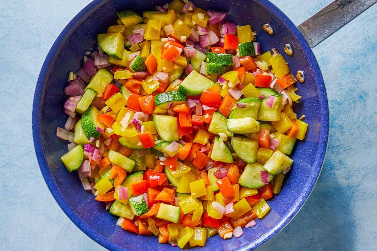 The vegetables for the crispy gnocchi with pesto in a skillet.