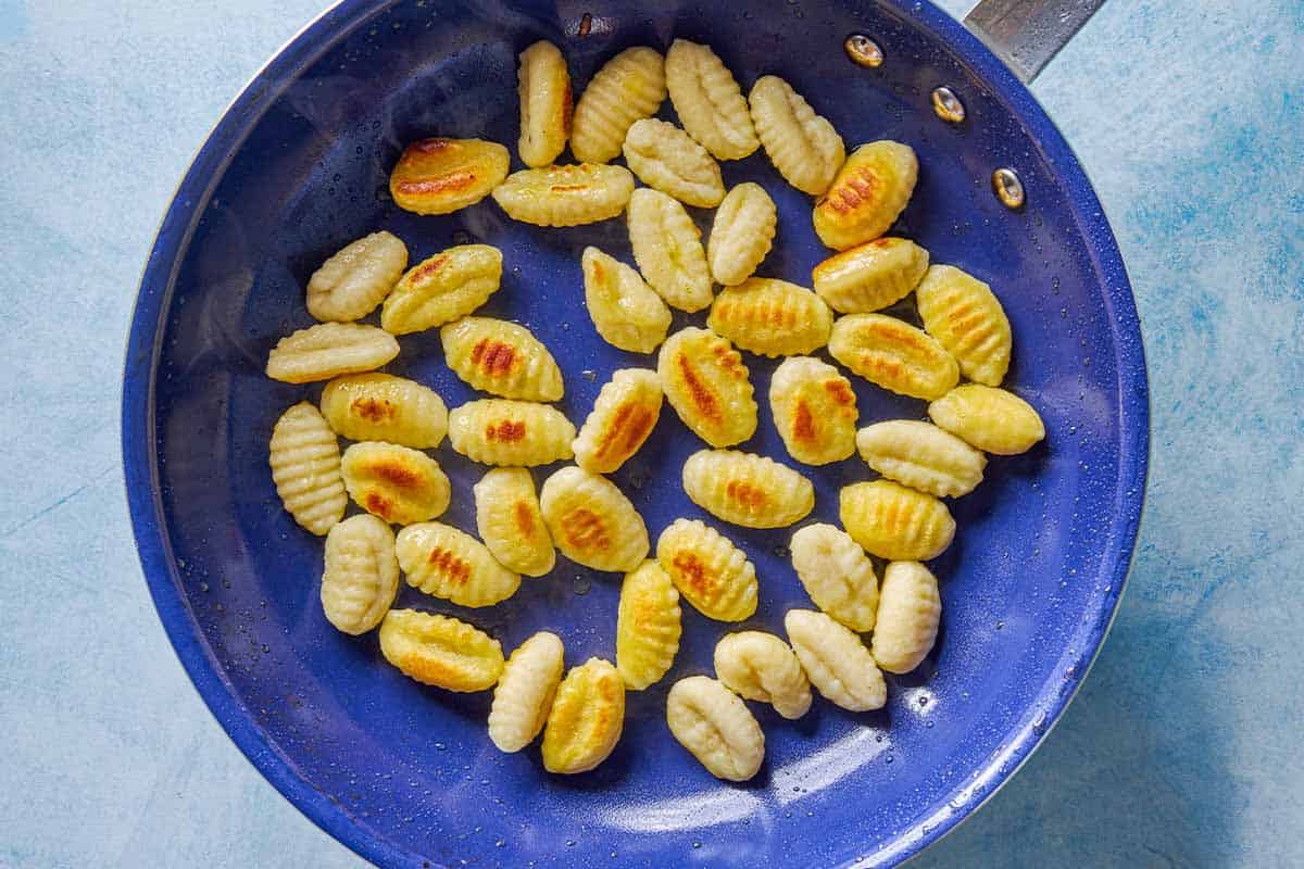 An overhead photo of gnocchi cooking in a skillet.