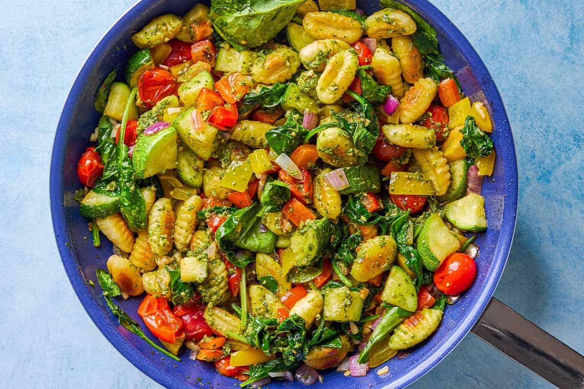 An overhead photo of crispy gnocchi with pesto in a skillet.