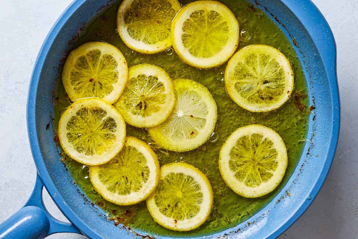 An overhead photo of lemon slices being fried in a skillet.