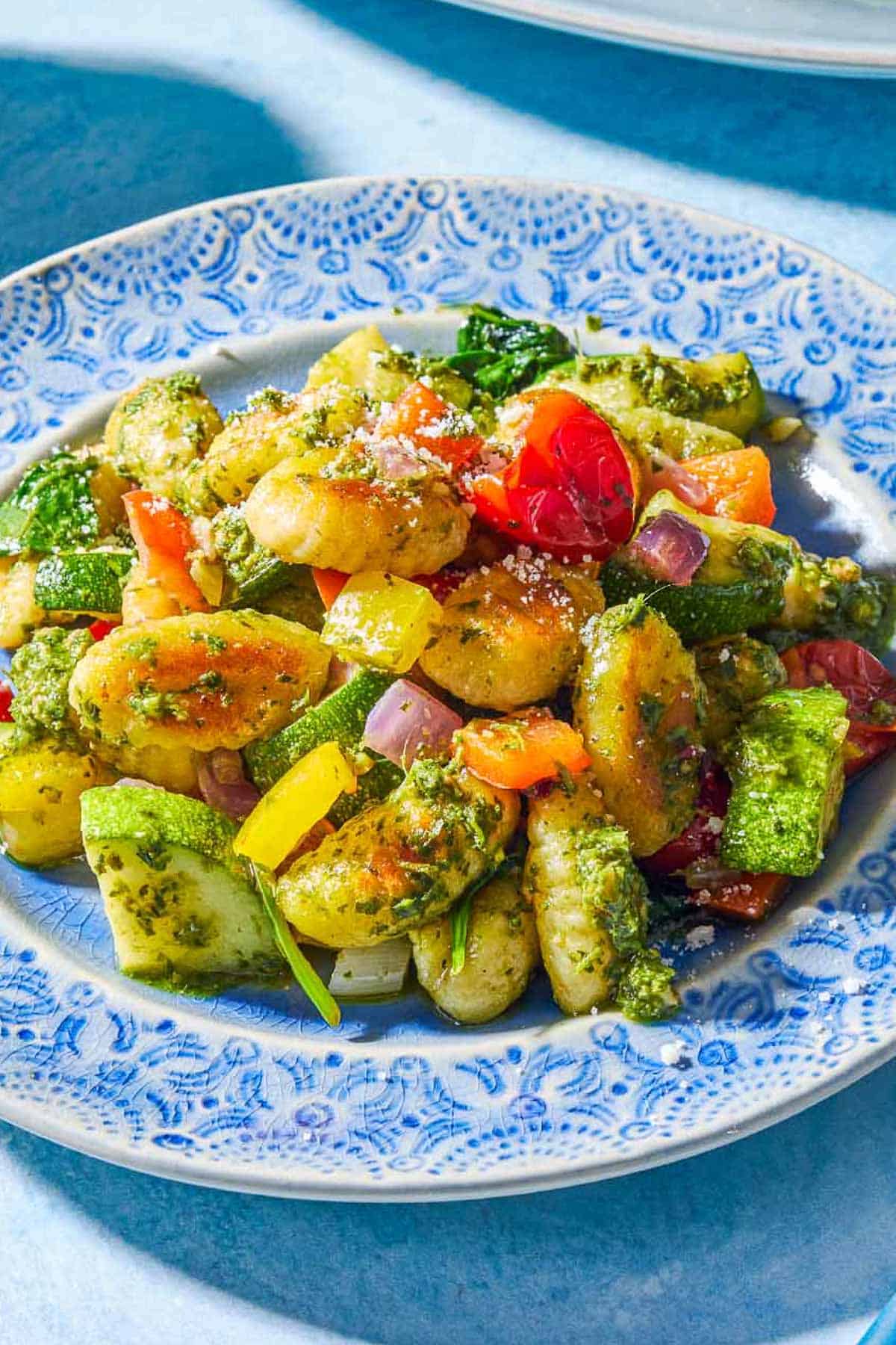 A close up of a serving of crispy gnocchi with pesto on a plate.