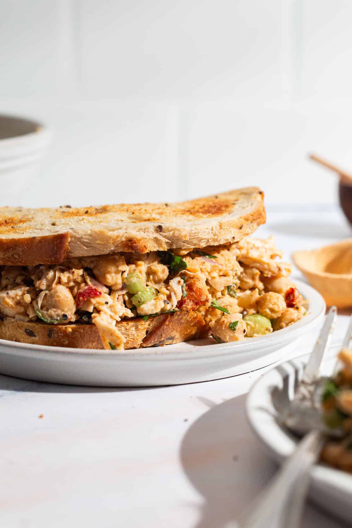 A close up of chickpea chicken salad sandwich on a plate.