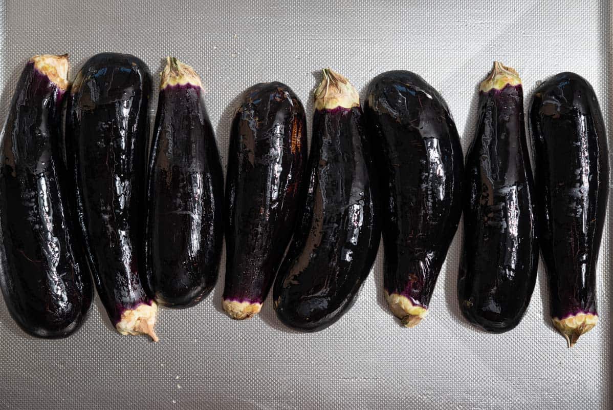 An overhead photo of 8 small globe eggplants.