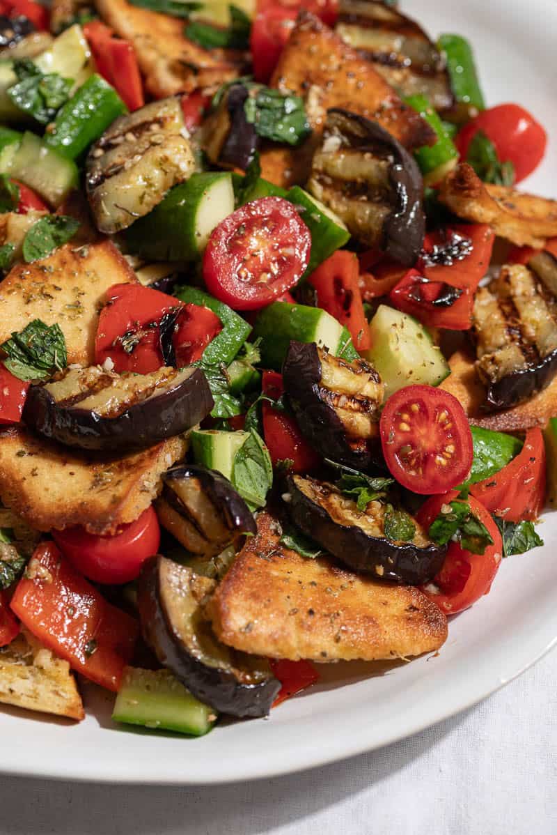 A close up of grilled eggplant salad on a serving platter.