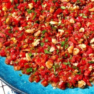 A close up photo of ezme turkish salsa on a platter.