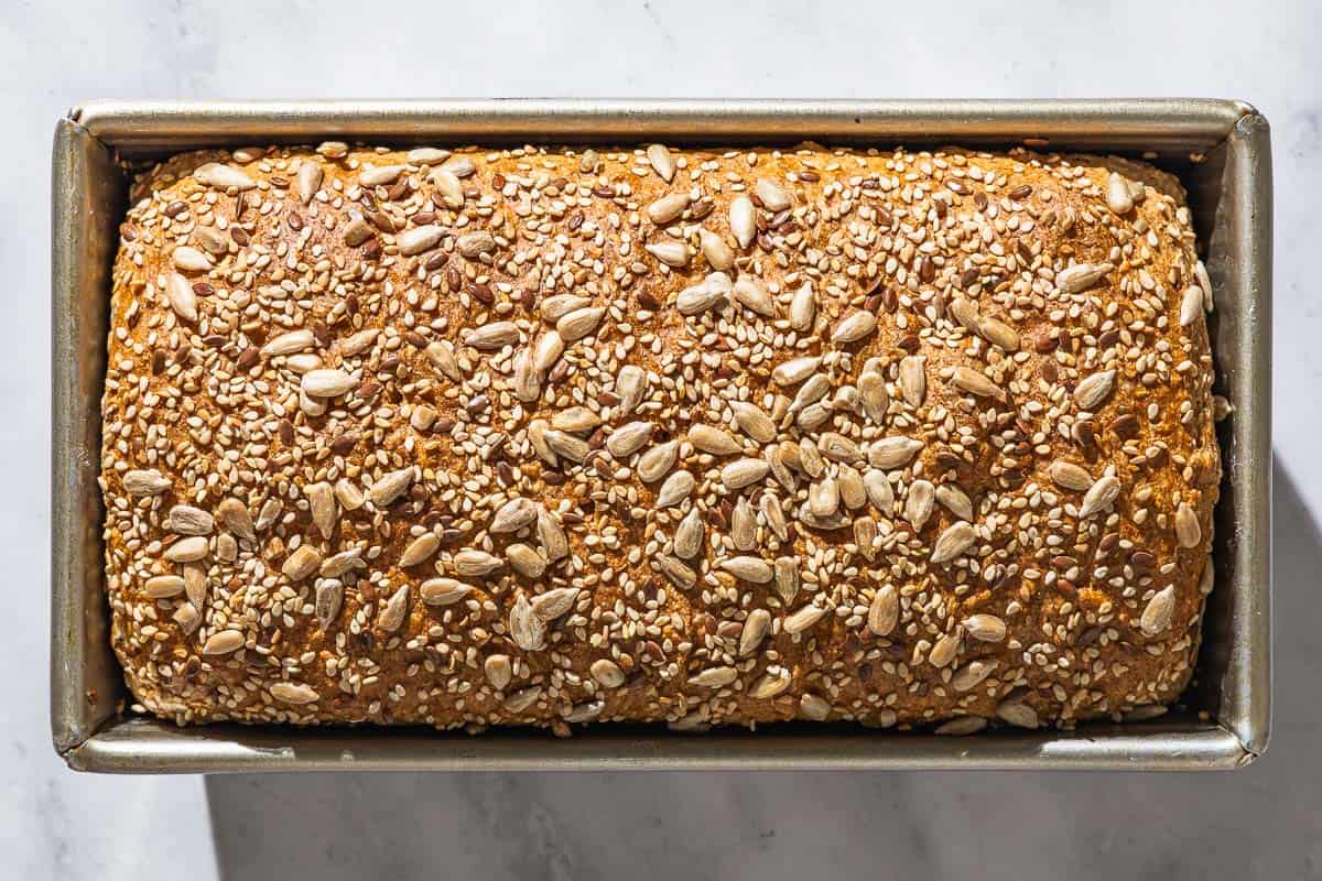 An overhead photo of baked whole wheat bread in a loaf pan.