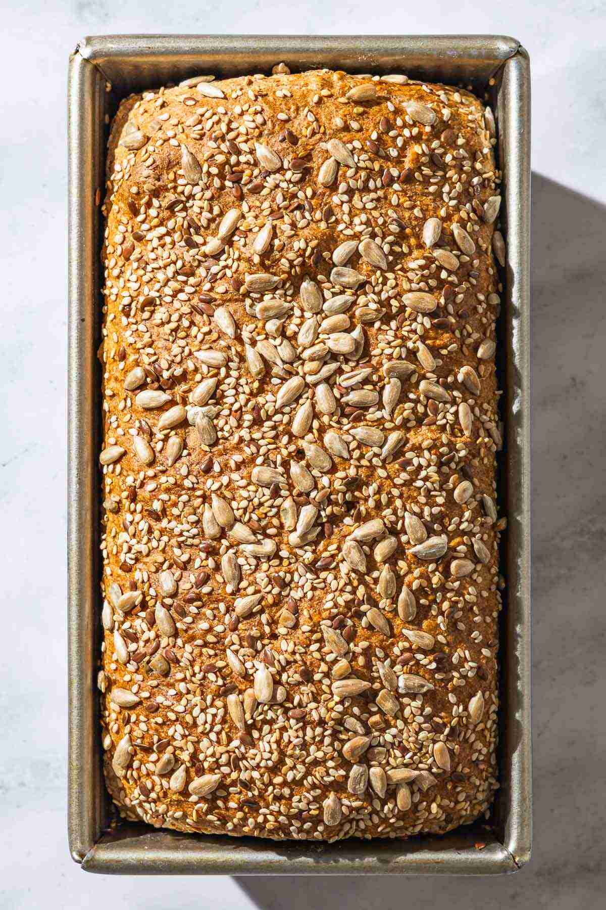 An overhead photo of baked whole wheat bread in a loaf pan.