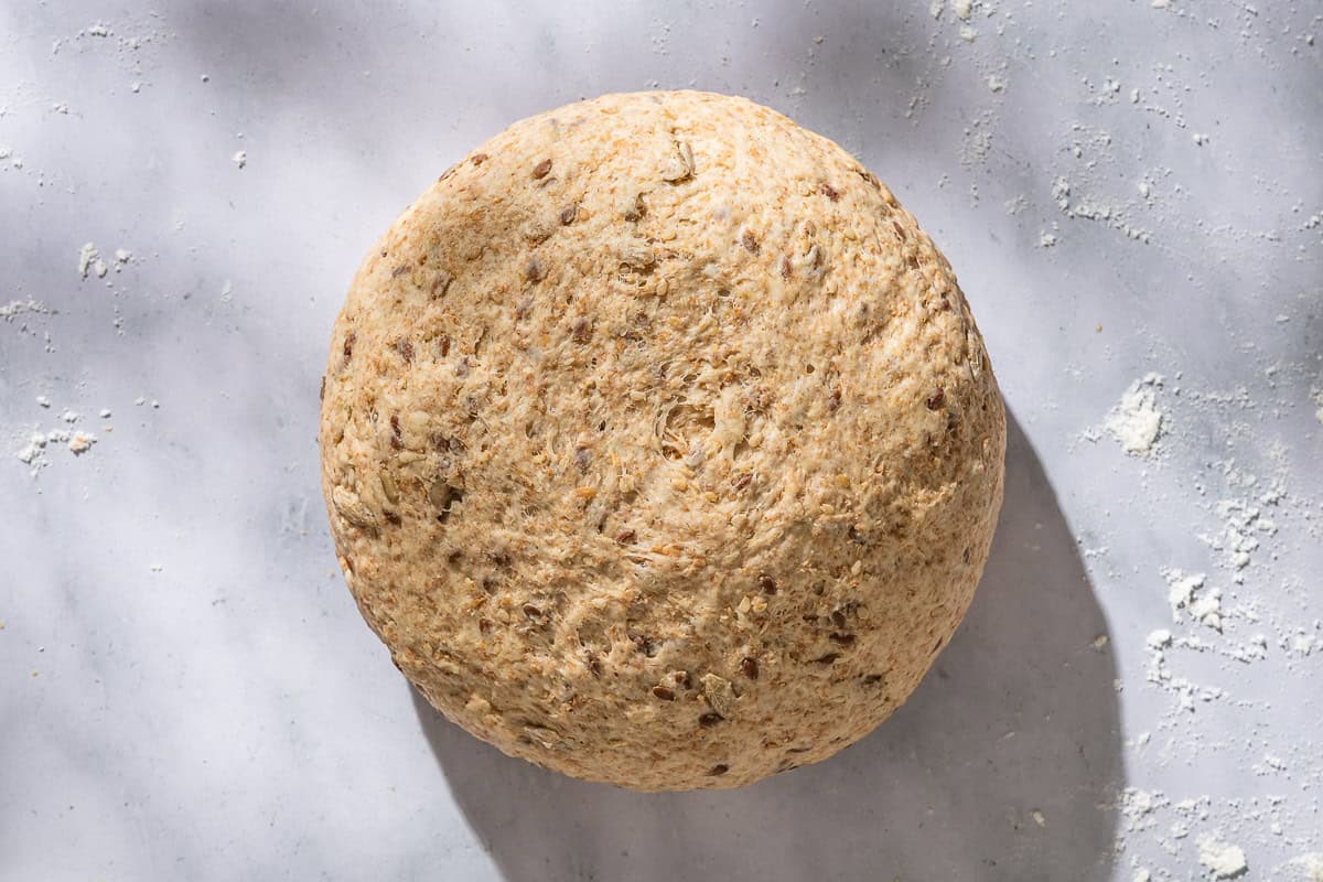 An overhead photo of a whole wheat bread dough ball.