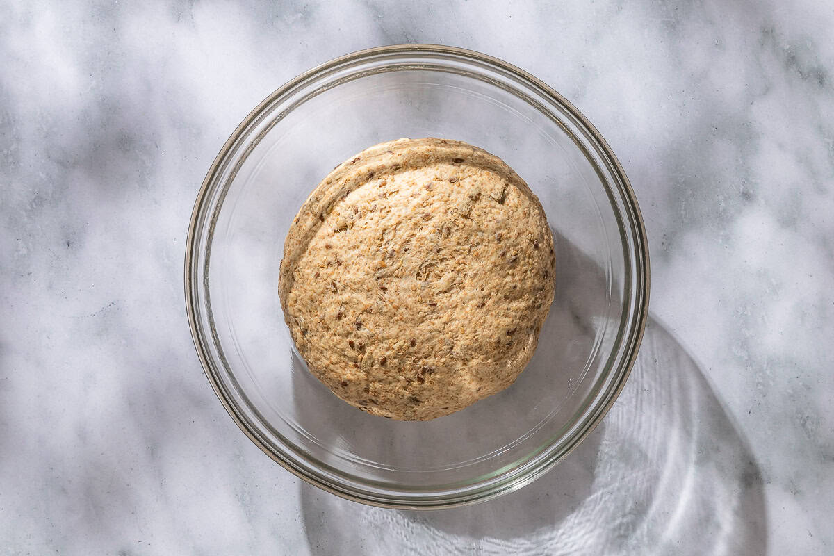 The whole wheat bread dough ball in a large bowl.