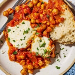 An overhead photo of a serving of chickpeas in tomato sauce on a plate with a fork.