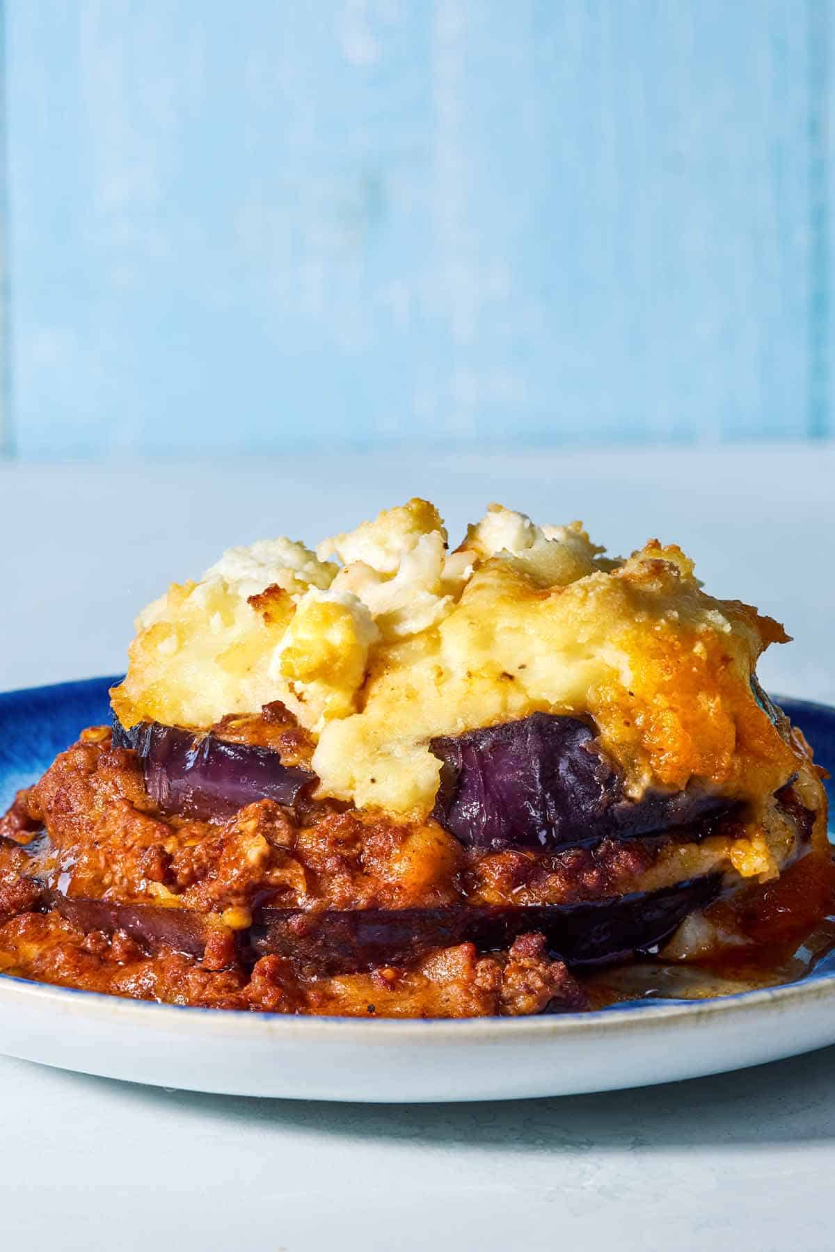 A close up of a serving of Greek Shepherd's Pie on a plate.