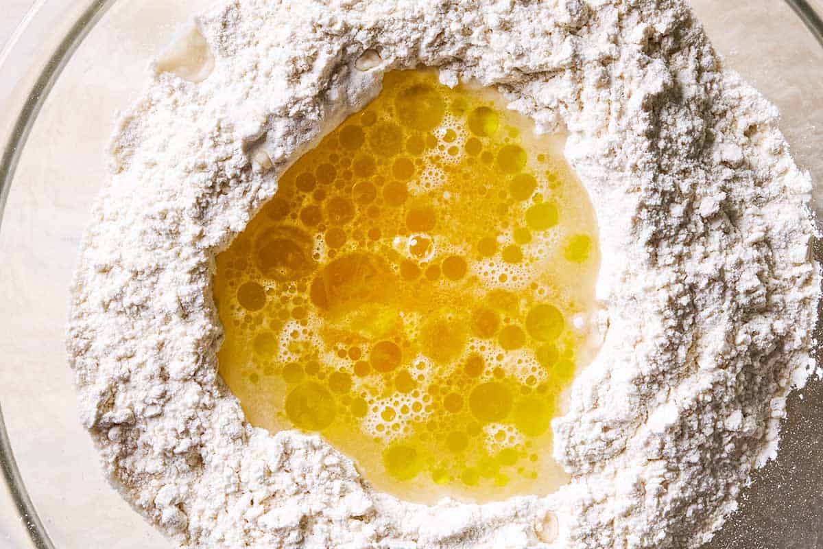 A combination of egg, oil and water in a well of a flour and salt mixture.