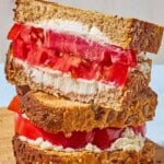 A close up of 2 tomato sandwiches stacked on top of each other.