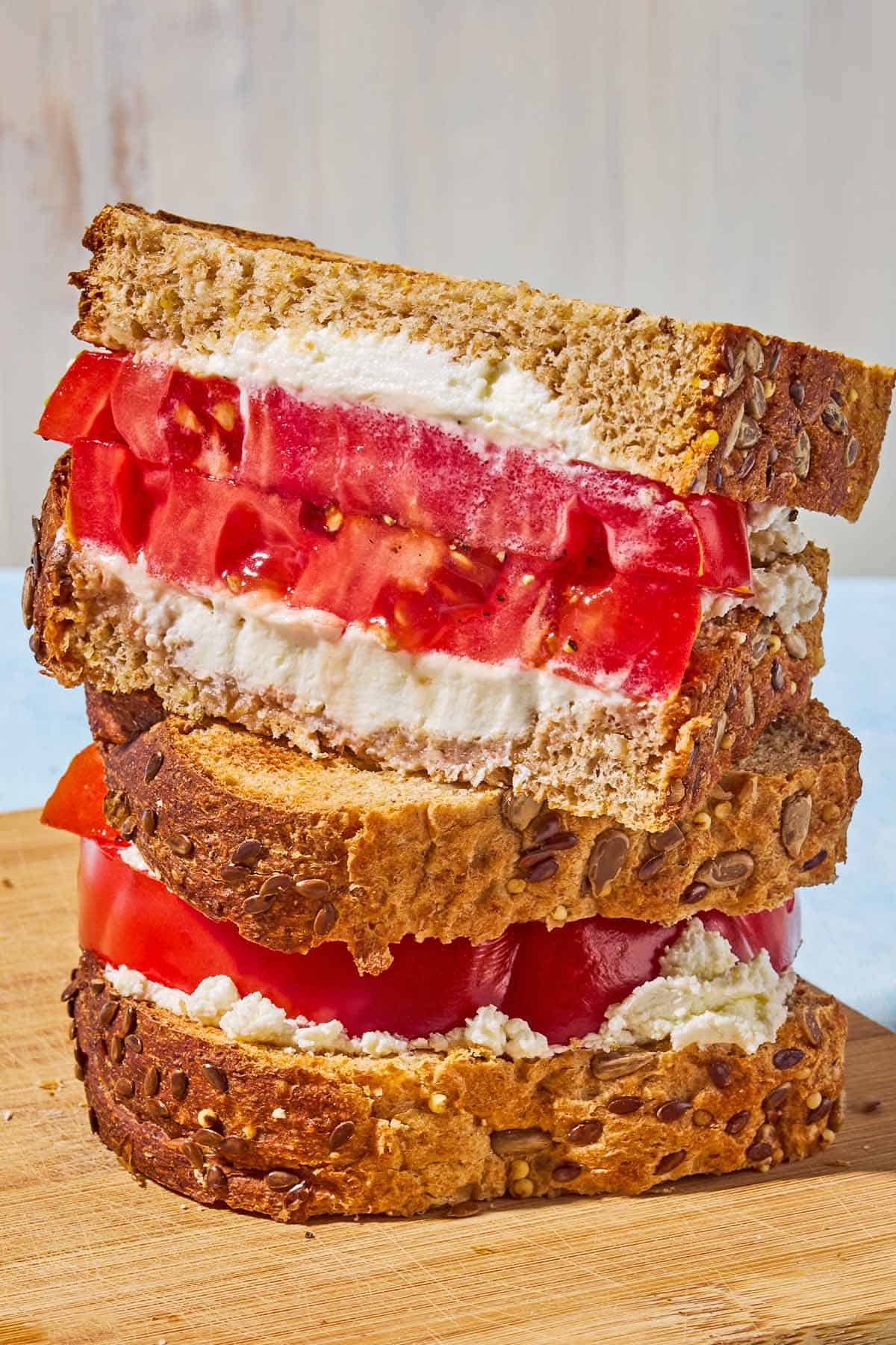 A close up of 2 tomato sandwiches stacked on top of each other.